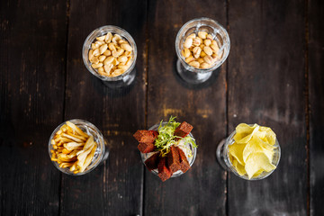 Assorted variety of beer bar snacks in glasses
