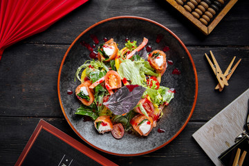Salmon rolls salad with vegetables and greens