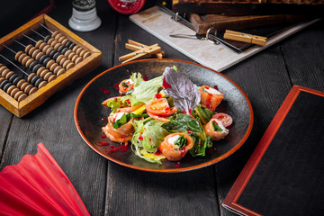 Salmon rolls salad with vegetables and greens