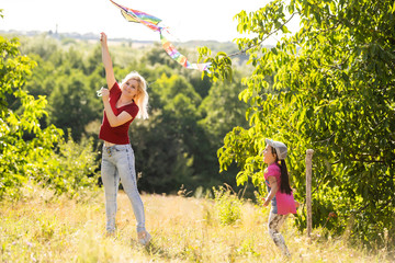 Young woman and girl flying a kite