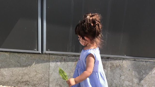 Ni&ntilde;a paseando al lado de una pared