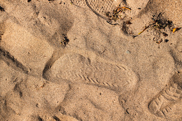 An image of shoe prints left in the sand at the beach
