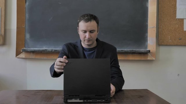 Male Teacher Working With Retro Vintage Laptop Computer At The Classroom
