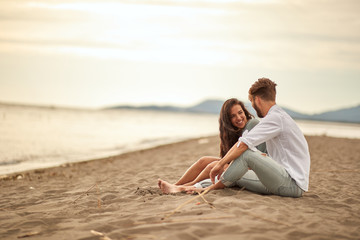 Young lovers on the beach and lovely moments on the sand