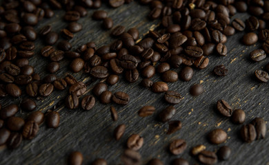 Roasted arabica coffee beans scattered on a wooden table. Fresh coffee beans.