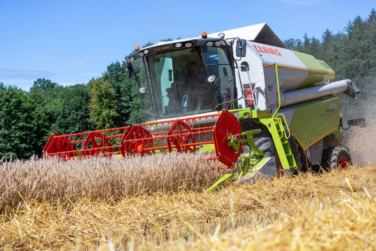 BAVARIA / GERMANY - AUGUST 20, 2020: Claas Tucano 420 combine harvester threshes grain in an agriculture field.