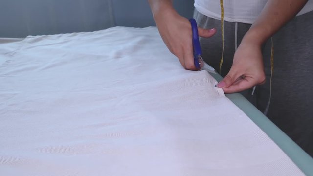 The cutter cuts the fabric with scissors.