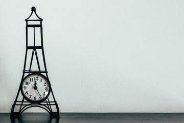 Black small Paris eiffel tower vintage decoration clock on a white background. Old romantic Clock with white space for announcemnts 