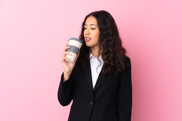 Mixed race business woman holding coffee to take away over isolated pink background