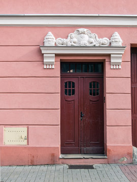 An old wooden door in a pink wall, Chełmno, Poland