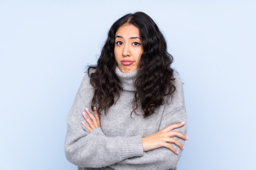 Spanish Chinese woman over isolated blue background making doubts gesture while lifting the shoulders