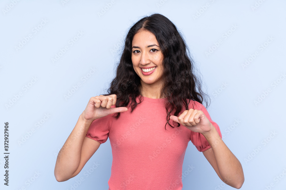 Wall mural Mixed race woman wearing a sweater over isolated blue background proud and self-satisfied