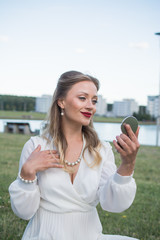 stylish elegant girl in a white dress is photographed in the city