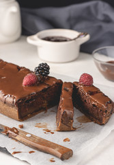 Homemade cinnamon cake with jam and dark chocolate, cut into pieces, close up view. Delicious cake, tasty cake.