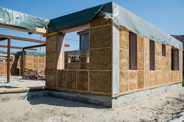 Construction of a house from an environmentally friendly material of plant origin. Frame made of wood, blocks of straw.