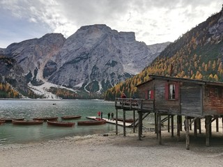 Jetty in lake between mountains, jetty in italy, boats in empty lake, Braies lake