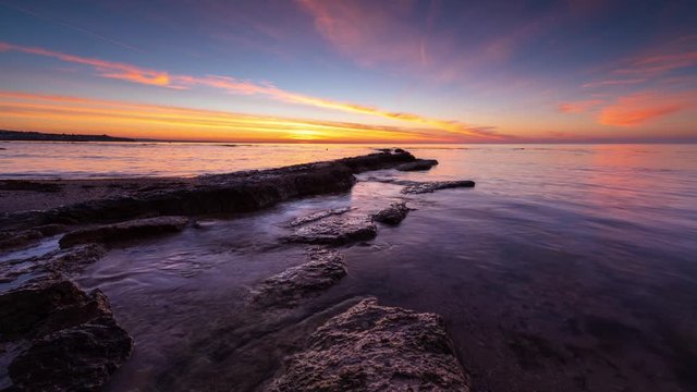 Time lapse with colorful sunset sky at rocky coastline and calm summer sea, the Black Sea coast, Bulgaria