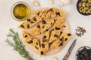 Focaccia bread with olives, garlic, oregano and olive oil, top view, flat lay.