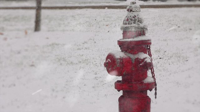 Snow covered red fire hydrant during a snow storm or blizzard