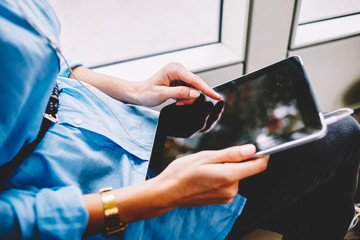 Close up view of tablet with mock up area in woman's hands.Cropped view of female passenger touching with finger on display of digital touch pad sharing media in networks via free transport internet