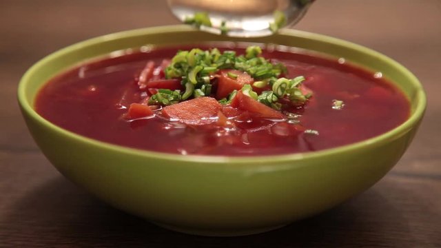 delicious red borscht in a green plate