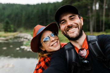 Selfie of a young couple in the mountains by the river