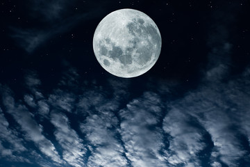Fototapeta na wymiar Full moon over clouds in the sky.