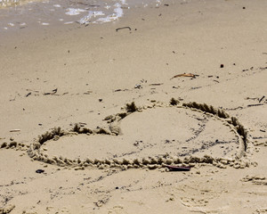 Heart of shells on the sand at the beach