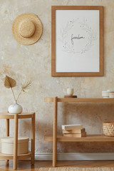 Bohemian interior of living room with mock up poster frame, elegant rattan accessories, dried...