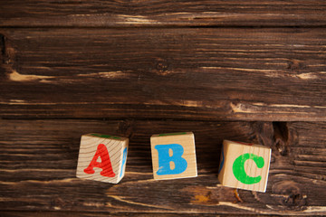 Cubes with letters ABC on rustic wooden table