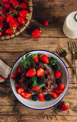 Chocolate waffles with milk and berries for breakfast. Chocolate cookies amerikaner shaped waffles.