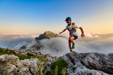Man ultramarathon runner in the mountains he trains at sunset - 372940955