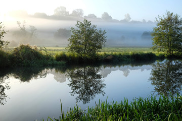 Early morning mist over the meadows on the River Wey in Godalming, Surrey, on a cold autumn morning.