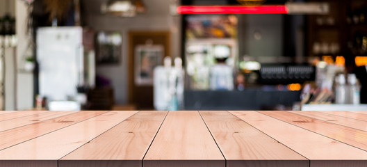Empty wooden table with blurred cafe and coffee shop interior background