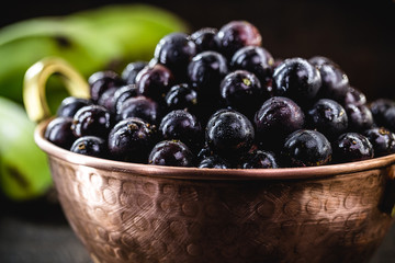 Jabuticaba. Brazilian and South American tropical fruits, in a copper pot on a rustic table
