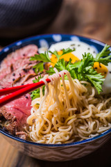 Ramen Soup with Wagyu Beef Filet on Bowl on wooden table. Beef ramen served in Asian style