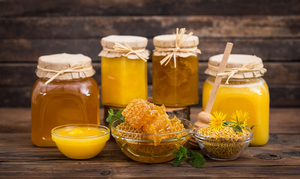 Fresh honey in the bowl and jars, with honeycomb and bee pollen