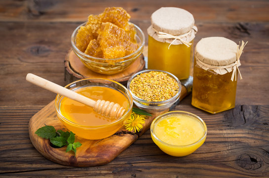 Fresh honey in the bowl and jars, with honeycomb and bee pollen