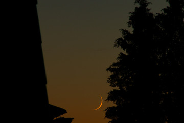 the crescent moon rising in the evening