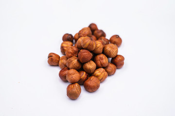 Whole hazelnut kernels lie on a white background. The autumn harvest.