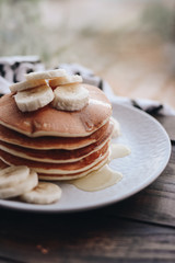 Delicious pancakes topped with banana and honey. Homemade classic american pancakes. Breakfast in the morning. 