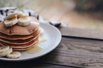 Delicious pancakes topped with banana and honey. Homemade classic american pancakes. Breakfast in the morning. 