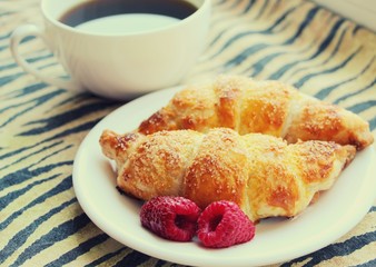 Fresh baked croissants with coffee for breakfast at home.