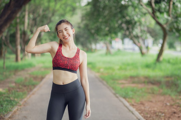 Asia women listen to music during a workout at the park.