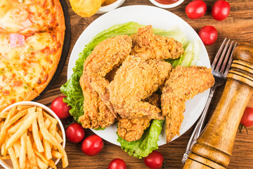 Fried chicken wings on wooden table.