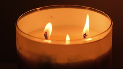 beautiful fire of a candle in a dark room, a warm yellow candle