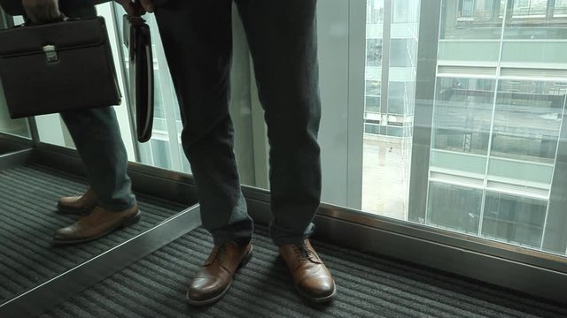 Businessman goes to the up by elevator in office skyscraper