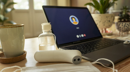 Self-isolation work from home. Medical mask on notebook laptop computer home working station. Protection mask anti virus corona ncov for safety quarantine