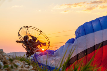 man with paramotor launching at sunset, Brazil