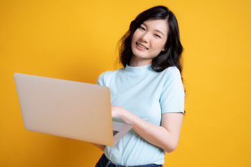 young woman holding a laptop isolated image on yellow background